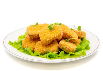 Chicken nuggets on a plate close-up on a white background.