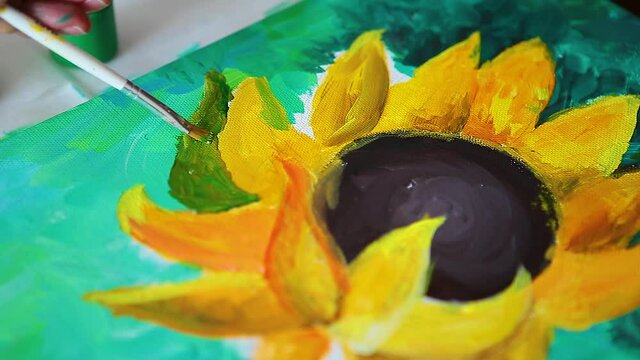  A hand with brush drawing picture of sunflowers by acrylic paints on canvas. Art concept.