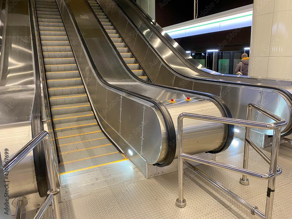 Poster large comfortable fast metal modern escalators with automatic steps for going up and down the subway