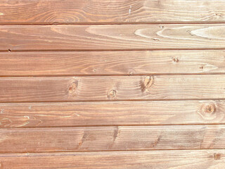 Beautiful wooden texture of horizontal multi-colored boards with knots on a brown wall surface. The background. Texture