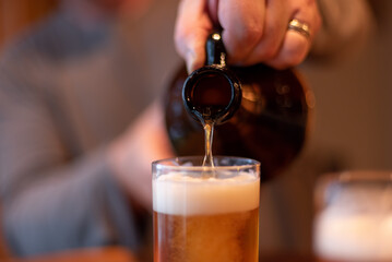 Closeup of craft beer being poured from a growler