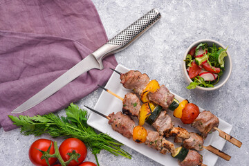 Shashlik - shish kebab of venison, roasted meat on skewer with garlic sauce, fresh and grilled vegetables	