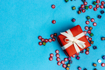 Obraz premium Gift wrapped in red paper and tied with a white ribbon.