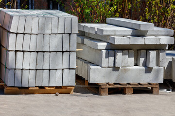 Concrete curbs are stacked against the backdrop of bright sunlight, close-up.