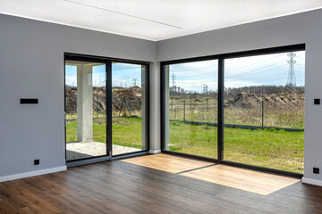 Large terrace windows overlooking the garden, the view from inside the living room on the floor are vinyl panels.