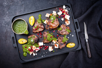 Traditional barbecue T-Bone lamb steaks with Greek feta cheese, chimichurri sauce and pomegranate...
