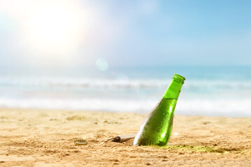 Beer bottle in sand on a beach a hot day