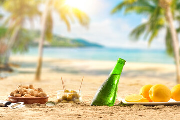 Beer buried in sand with aperitif on a beach