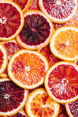 Bright colorful background of fresh ripe sliced blood oranges. Close up, flat lay, top view. Blood...