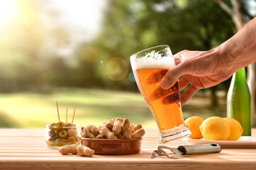 Man having a snack in countryside with beer in hand