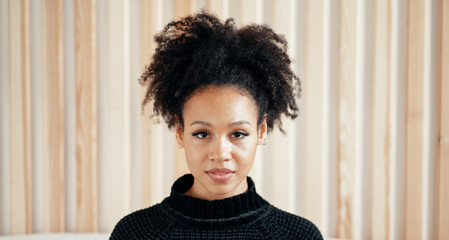 Portrait of a woman of African American appearance. A smart student gets an education through video communication, looks at the monitor.