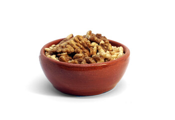 Ceramic, glazed bowl with walnuts and pine nuts. Isolated on white background.