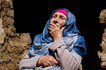 The face of an old grandmother close up. The old grandmother in the background of the slums. Grandmother's wrinkled hands close up. Poverty and poverty. An old woman in the ruins. Help for the elderly