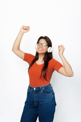 A cheerful young girl is dancing happily with her headphones on