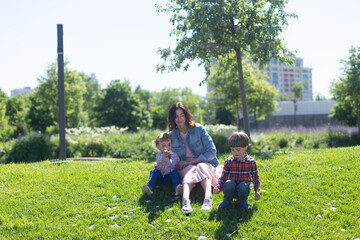 Obraz premium Happy mother with her children spends time in city park