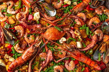 Paella. Spanish dish of rice and seafood, vegetables and chicken. Shrimp, octopus, crab and mussels. Banquet festive dishes. Gourmet restaurant menu. White background. Pattern