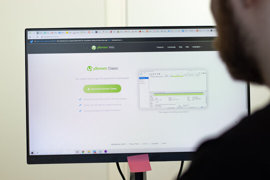New York, USA - 26 April 2021: uTorrent website page on screen, man using service, Illustrative Editorial.
