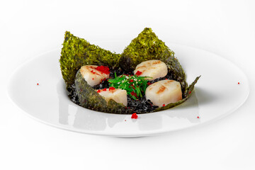 Delicate fragrant scallops in black risotto with cuttlefish ink. Seafood dish. Seafood dish. Gourmet restaurant menu. White background. 