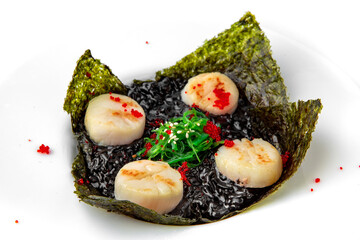Delicate fragrant scallops in black risotto with cuttlefish ink. Seafood dish. Seafood dish. Gourmet restaurant menu. White background. 