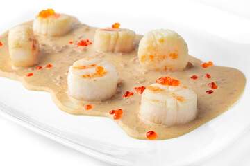 Delicate fragrant scallops in a creamy sauce with red caviar. Seafood dish. Gourmet restaurant menu. White background. 