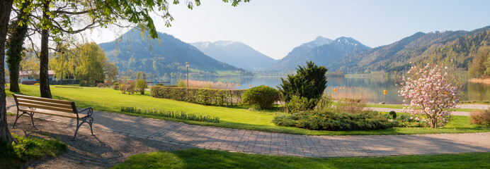 spa garden Schliersee with bench and lake view, bavarian landscape at springtime