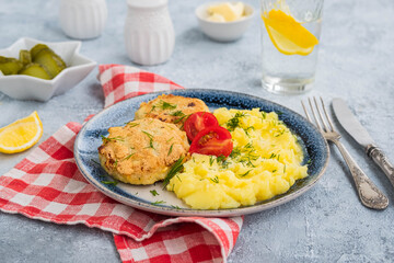 Homemade fish cakes or cutlets with mashed potatoes on a blue plate on a light concrete background. Fish recipes.