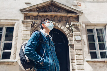 Tourist man walking in Olesko Castle yard wearing mask. Travelling during coronavirus covid pandemic in Ukraine.