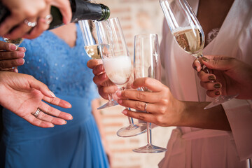 several girls serving champagne and drinking before the wedding