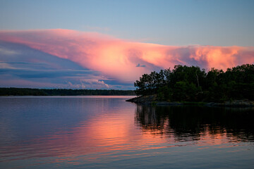 Sun illuminating clouds over a lake in beautiful colors