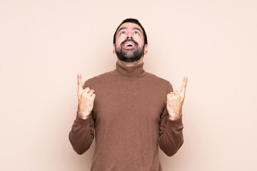 Fototapeta premium Man over isolated background surprised and pointing up