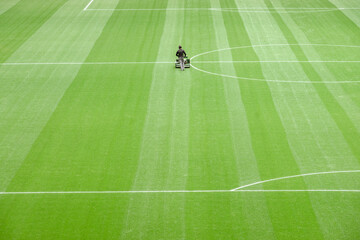 a person working in maintenance of a soccer field. View from above of a soccer field with an unrecognizable person.NEF