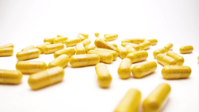 colorful nutritional diet supplement vitamin pills capsules on a white background (looping)