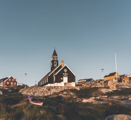 Old wooden Zions Church in arctic city of Ilulissat, with midnight sun light and blue sky in North...
