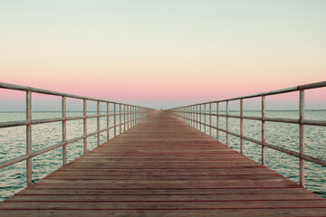 Fototapeta na wymiar wooden bridge over the sea, summer sunset 
