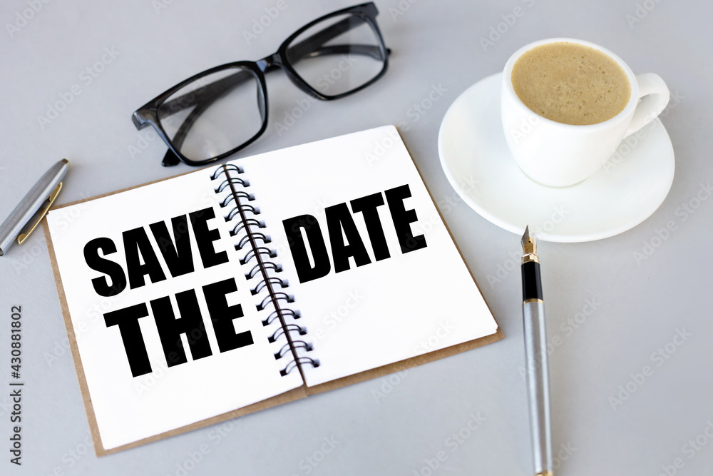 Poster save the date. text on white notepad paper. near cups with coffee on a gray background