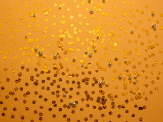 Jewelry made of pearls on a gold background. Shiny confetti. Fashionable sparkling background. Flat...