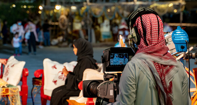 An Arab man recording a live interview video at an outdoor event in Qatar. Selective focus