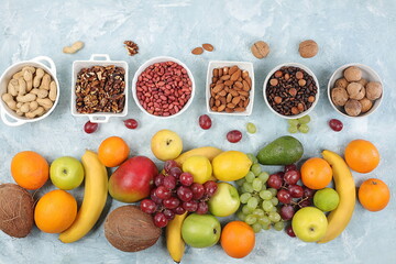 Fresh summer tropical fruits and nuts assortment on a bright sunny table, citrus mix, detox diet and weight loss concepts, banner, advertising for a store, healthy and natural food, selective focus