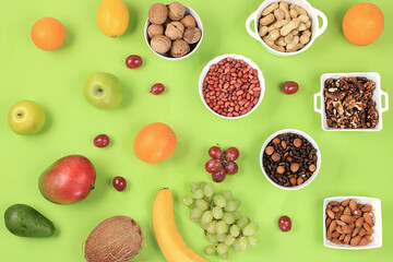 Fresh summer tropical fruits and nuts assortment on a bright sunny table, citrus mix, detox diet and weight loss concepts, banner, advertising for a store, healthy and natural food,