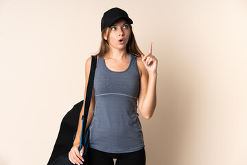 Young sport Lithuanian woman holding a sport bag isolated on beige background thinking an idea pointing the finger up