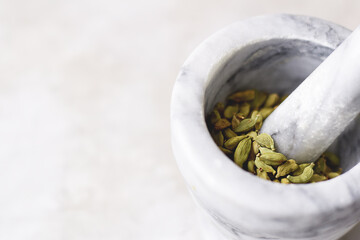 Cardamom pods in a marble mortar with copy space