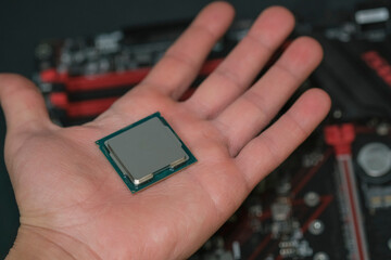 Man hand hold desktop pc cpu processor over hi tech motherboard,computer components chip