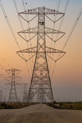 high voltage electric towers during sunset.