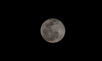 Full moon over dark black sky at night. Selective focus