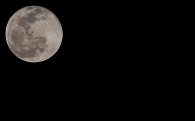 Full moon over dark black sky at night. Selective focus