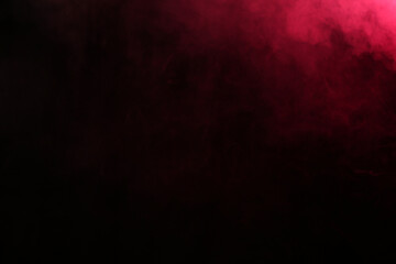 Smoke in red light on black background