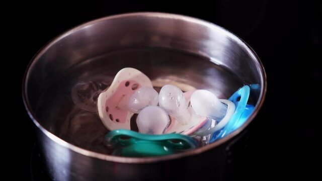 Baby Pacifier Soothers Sanitized and Disinfected in Pot of Boiling Water to Prevent Infant Thrush Oral Infection
