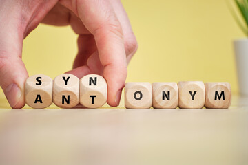 Concept synonym and antonym on wooden cubes.