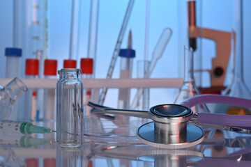 Lab desk with chemical glassware and medical stethoscope. Test tubes, liquid flasks, medical gadgets in chemical laboratory. Biotech research laboratory with biochemicals on the lab table.