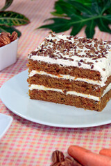 Slice of homemade carrot cake with cream and nuts. 